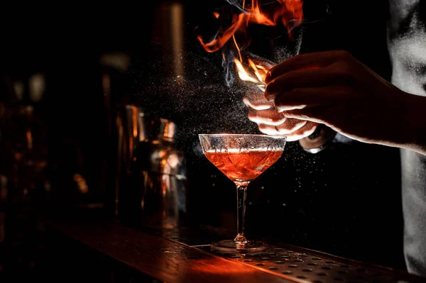 Barmans mains saupoudrer le jus dans le verre à cocktail — Photo