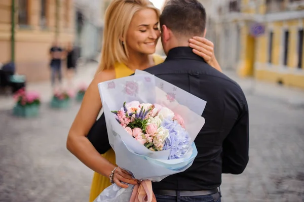花束を持つ少女が彼氏を抱擁します。 — ストック写真