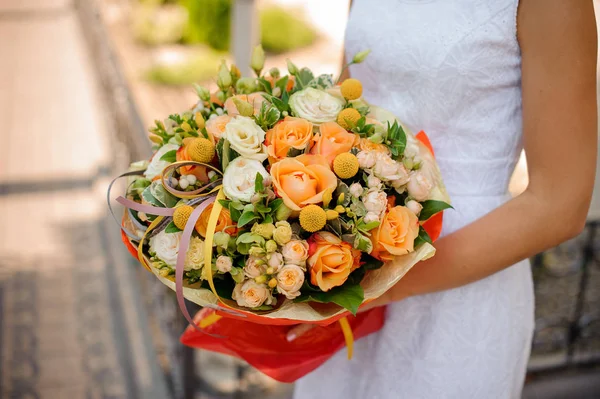 Vrouw houdt een boeket van kraspedia, rozen, pion-vormige rozen en vetplanten — Stockfoto