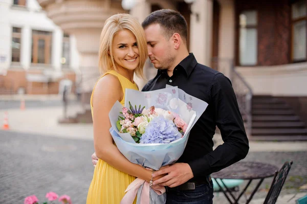 Jonge en mooie paar met een mooi boeket bloemen — Stockfoto