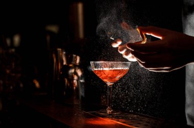 Barmen bir portakal kabuğu kokteyl cam spreyler