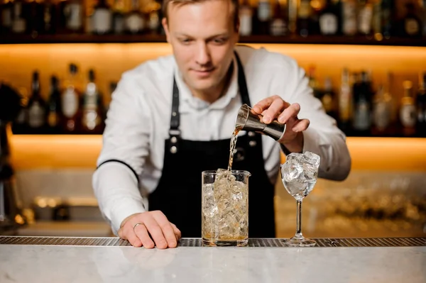 Barman en el pub vierte whisky sobre hielo en un vaso — Foto de Stock
