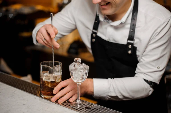 Barman mezcla hielo en whisky con cuchara — Foto de Stock