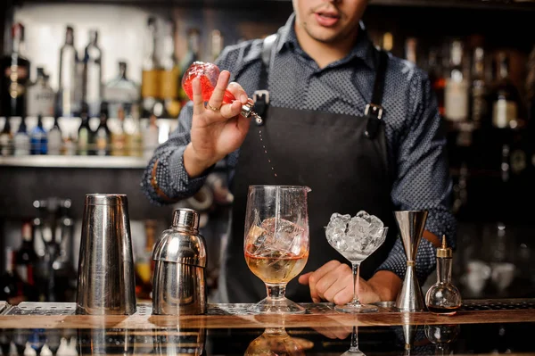 Bartender derrama xarope em copo de cocktail com gelo — Fotografia de Stock