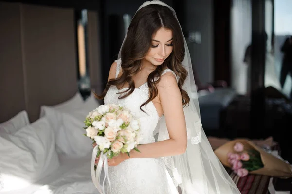 Retrato de novia glamour en vestido de novia elegante, velo y ramo — Foto de Stock