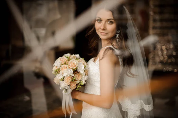 Morena novia sonriendo y celebración de boda ramo de rosas — Foto de Stock