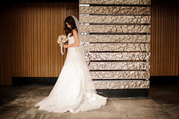 Vestido de novia y velo de pie cerca del objeto de arte — Foto de Stock