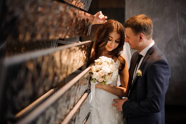 Braut steht mit Bräutigam in der Nähe des Kunstobjekts — Stockfoto