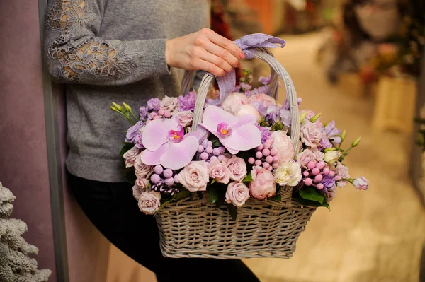 여자는 장미와 난초를 포함 하 여 보라색 꽃 바구니를 보유 하 — 스톡 사진
