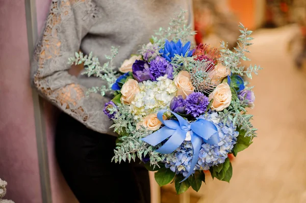 Femelle tient un bouquet avec des hortensias bleues et blanches, des roses beiges et des succulentes — Photo