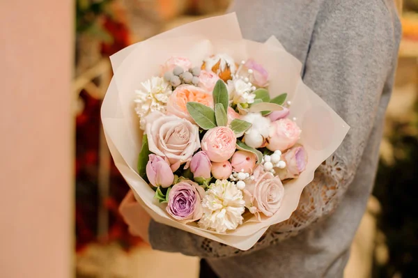 Vrouw houdt een groot boeket met rozen, pion-vormige rozen en eucalyptus — Stockfoto