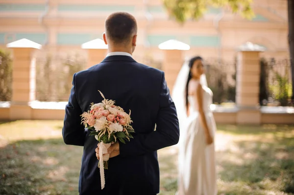 Bräutigam im stilvollen Hochzeitsanzug mit Blumenstrauß — Stockfoto