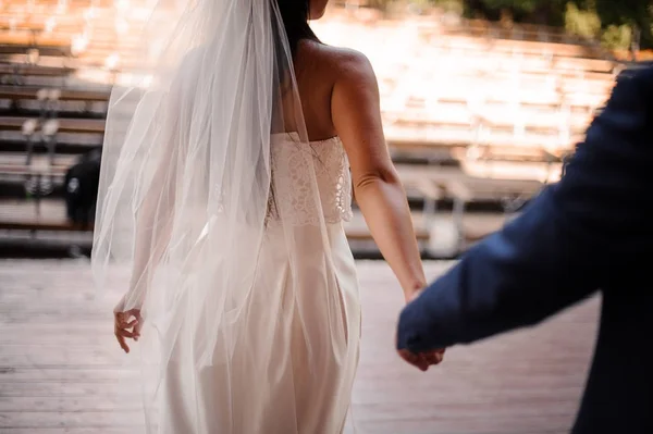 Groom seguindo sua bela noiva vestida com um vestido branco — Fotografia de Stock
