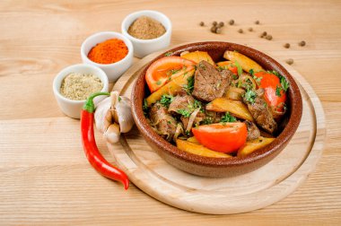 Ojahuri biber, sarımsak, karabiber ve baharatlar ile dekore edilmiş bir tabak içinde