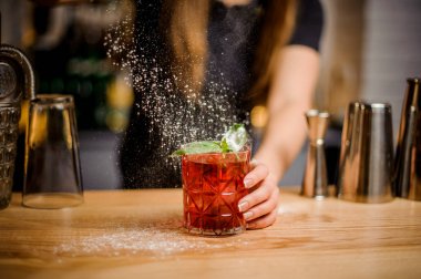 blondy barmen bir acı toz şeker ekleyerek kokteyl hazırlanması tamamlanır
