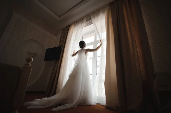 穿着白色连衣裙的新娘打开窗帘 — 图库照片
