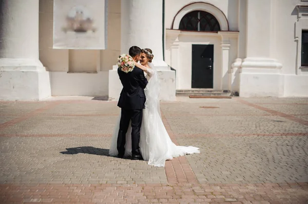 Groom and bride with a bouquet , hug on the street — Stock Photo, Image