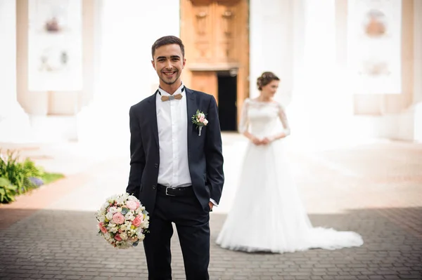 Brautjungfer hält einen Brautstrauß in der Hand und lächelt — Stockfoto