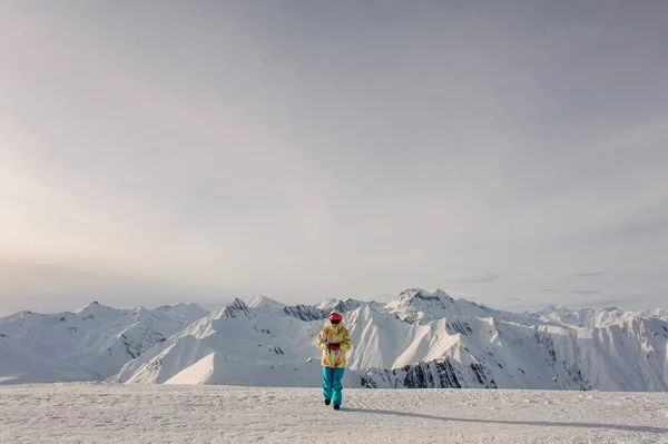 Femme snowboarder en vêtements de sport marchant sur le beau backgr — Photo