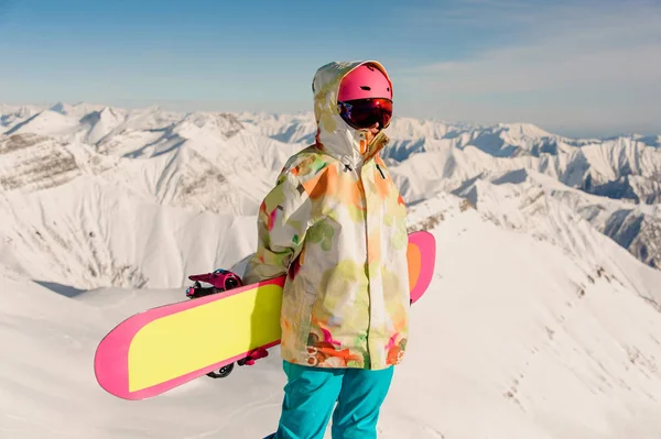 Mulher snowboarder em sportswear em pé no pico da montanha — Fotografia de Stock