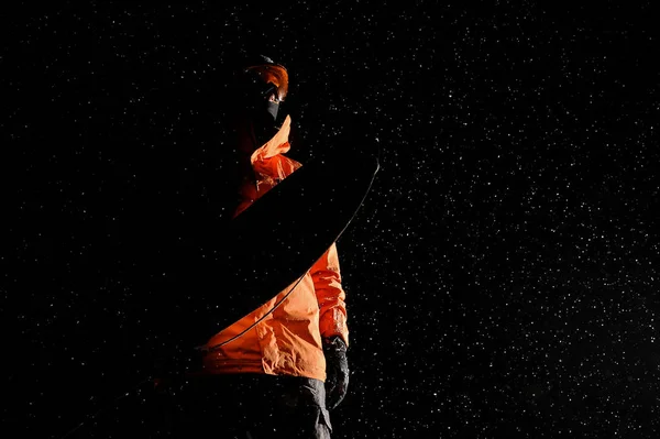 Unterseite der abgedunkelten Figur eines männlichen Snowboarders mit einem Snowboard — Stockfoto