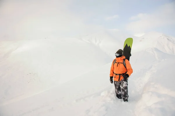 Cavaleiro de snowboard masculino em pé no fundo das montanhas — Fotografia de Stock