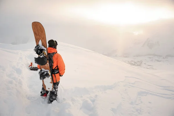 Achteraanzicht van snowboarder op zoek op bergtoppen — Stockfoto