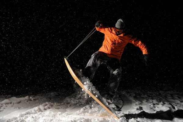 夜雪の上ジャンプ男性プロスノーボーダー — ストック写真