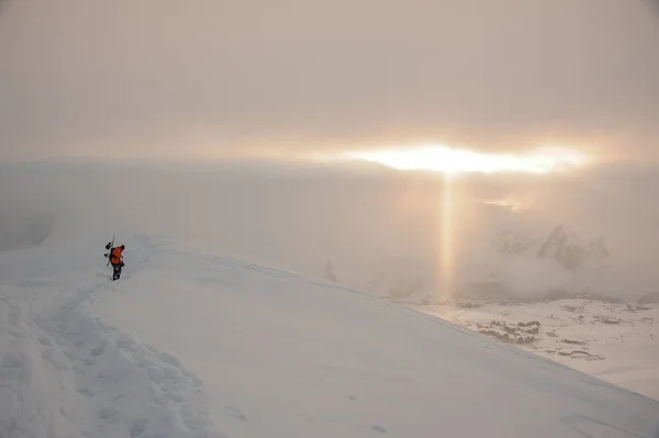 滑雪板在高高的山峰上行走在太阳光线下 — 图库照片