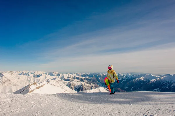 Femme snowboarder en vêtements de sport marchant sur le sommet de la montagne — Photo