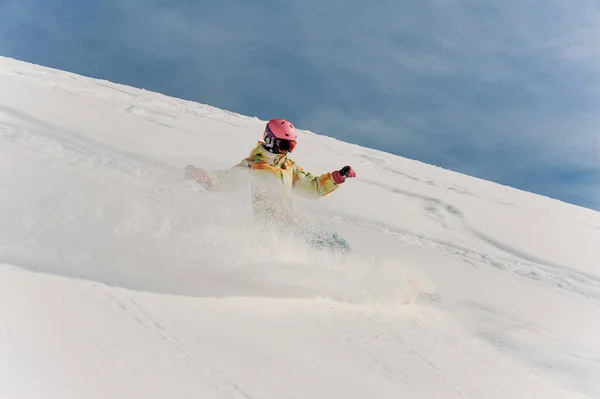 Feminino snowboarder no colorido sportswear e rosa capacete equitação — Fotografia de Stock