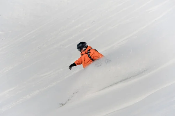 雪の斜面下に乗って男性スノーボーダー — ストック写真