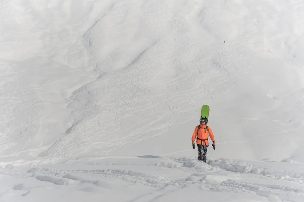 Snowboarder che cammina con una tavola alle spalle — Foto Stock
