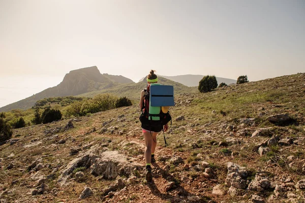 Flicka traveler promenader längs en stenig Stig i bakgrunden av berg — Stockfoto