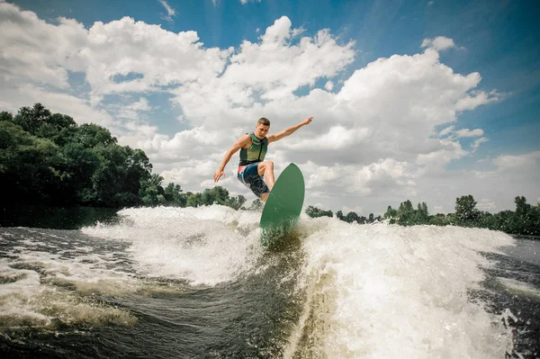 Mâle en bonne santé chevauche les vagues dans une rivière d'été — Photo