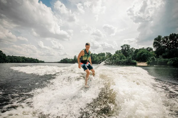 athletic surfer riding wakeboard to perform his professional ski