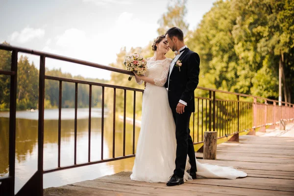 Casal de casamento jovem e atraente na ponte — Fotografia de Stock