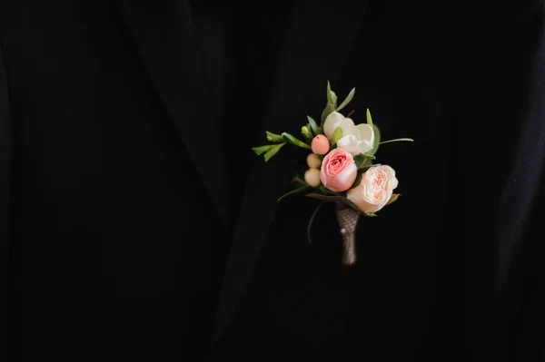 Hermoso boutonniere de boda en un traje negro — Foto de Stock