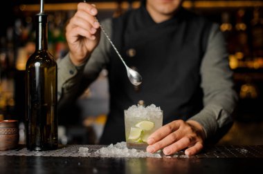 Barmen Cachaça kireç ve buz Caipirinha horoz yapım ile karıştırma