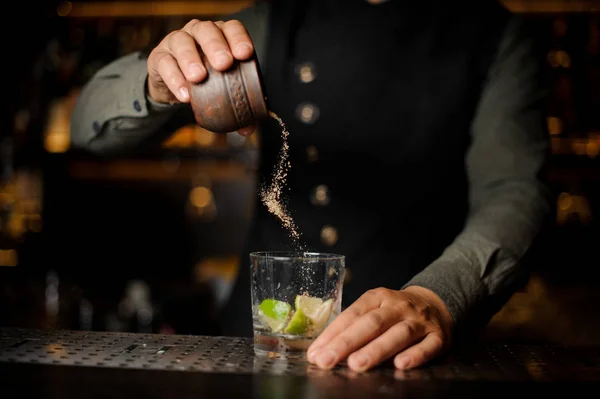 Barman ajoutant du sucre de canne dans le verre à cocktail avec de la lime. P — Photo