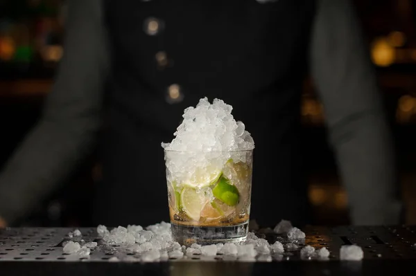 Bicchiere da cocktail riempito con ghiaccio, lime e zucchero di canna. Processo di preparazione del cocktail Caipirinha — Foto Stock