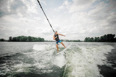 Genç ve atletik erkek wakesurfing bir kablo holding yönetim kurulu