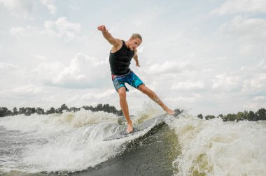 Atletik erkek wakesurfing gökyüzüne karşı yönetim kurulu