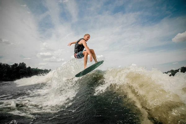 Hombre activo saltando sobre las olas del río — Foto de Stock