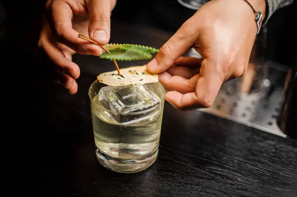 Barkeeper Hände dekorieren ein Cocktailglas mit alkoholischen Getränken — Stockfoto
