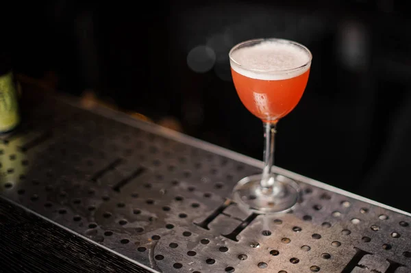 Een elegante glazen gevuld met een smakelijke oranje alcoholische drank — Stockfoto
