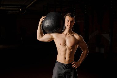 Genç ve yakışıklı bir spor salonu ile bir tartmak crossfit pratik