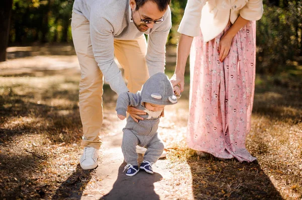 Dítě dělá první krůčky, držení rukou otec a matka — Stock fotografie
