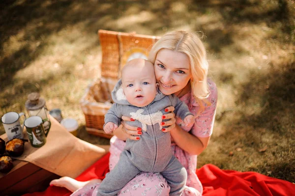 Mooie blonde moeder knuffelen van een schattige baby-zoon — Stockfoto