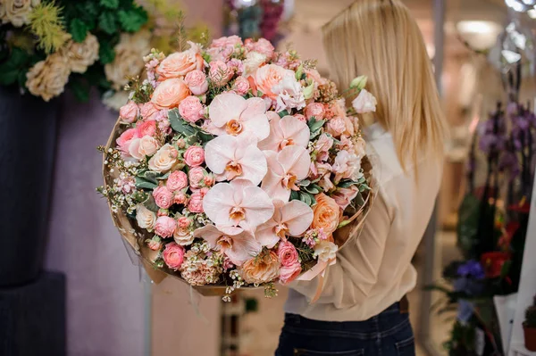 Vista posterior de una mujer con un ramo de flores —  Fotos de Stock